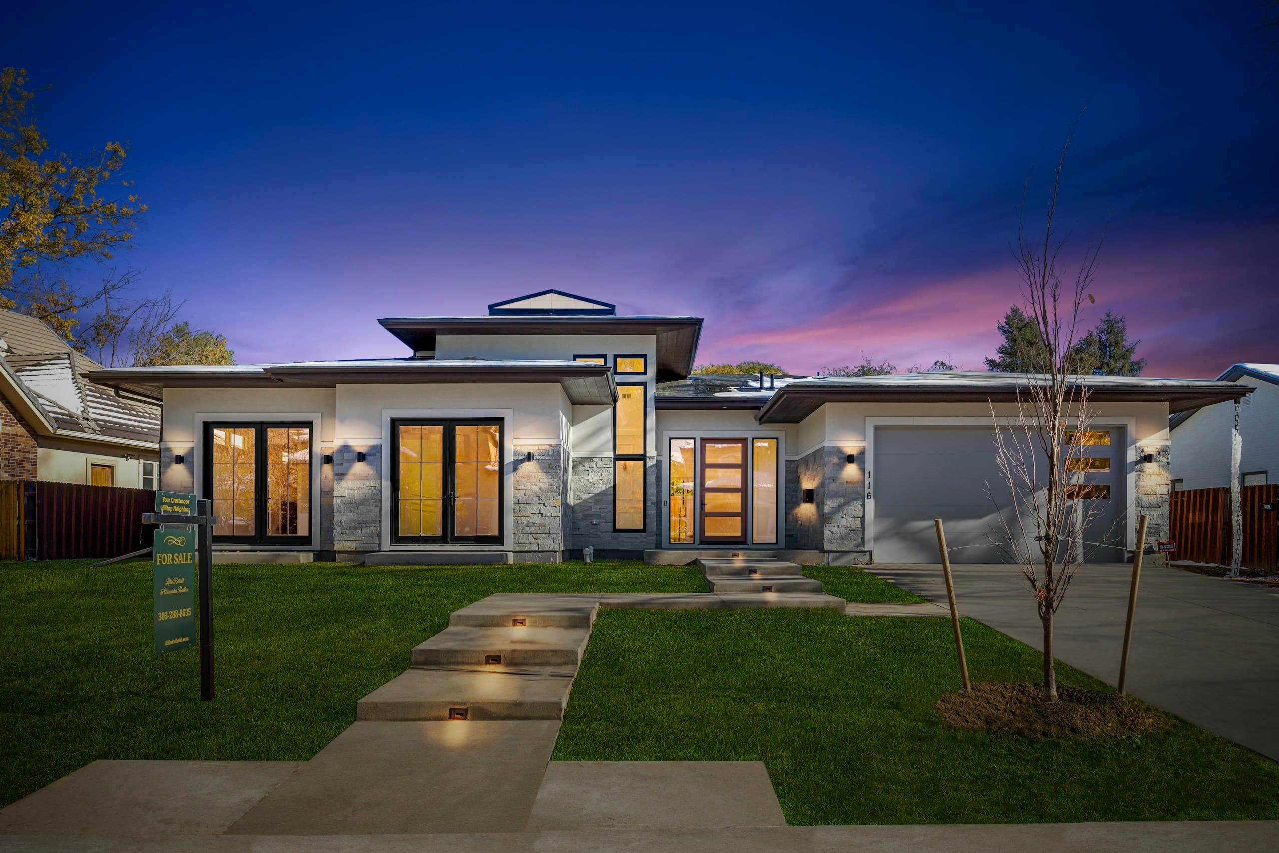Modern bungalow at twilight with a lit front lawn