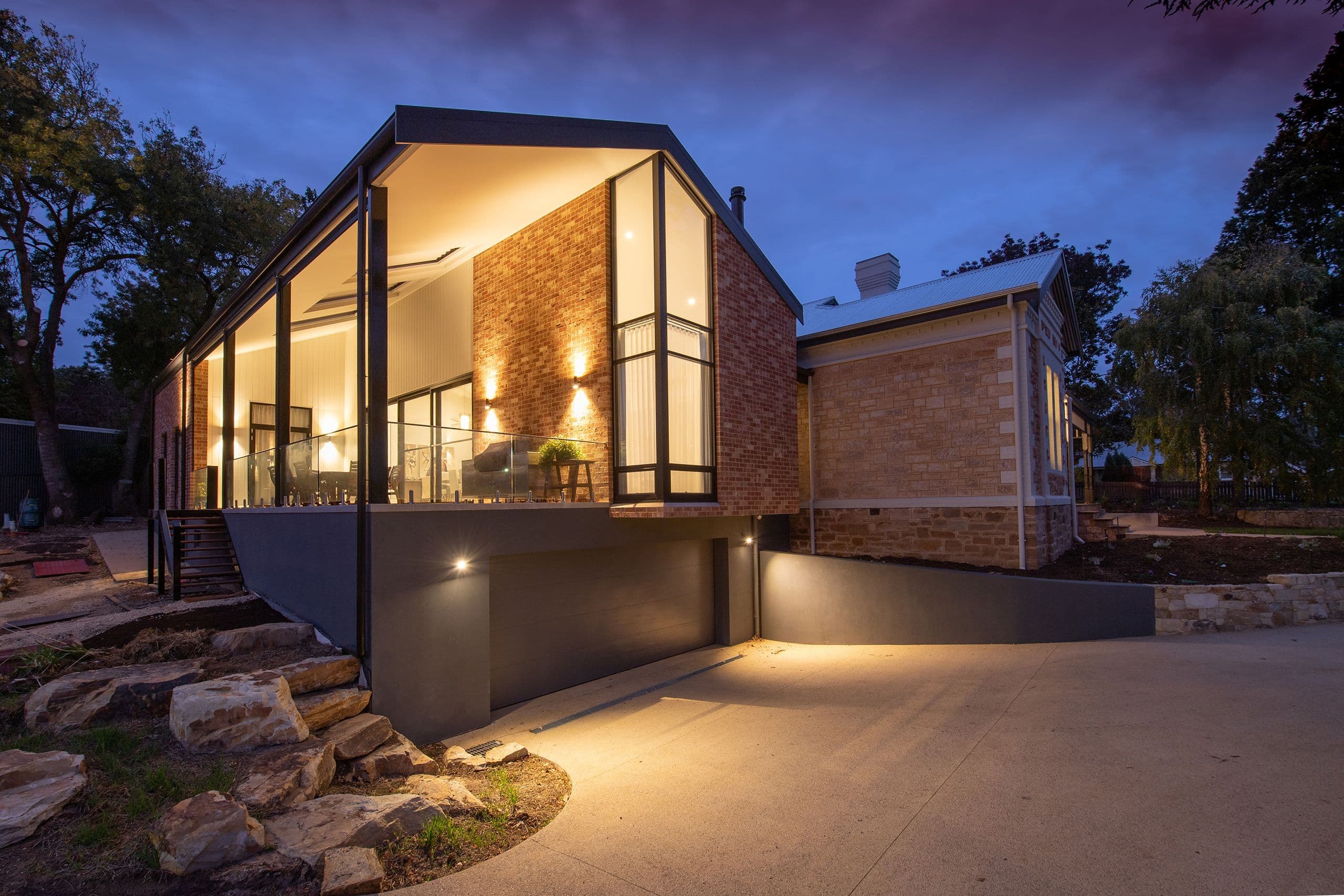 Modern gable home at twilight with its windows lit